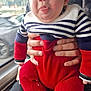 Ewen participe au concours pour gagner de l'argent avec cette photo : adult, baby, child, clothing, cute, expression, face, funny_face, hands, holding, human, indoor, knitwear, person, portrait, red_pants, seat, striped_sweater, tongue_out, window