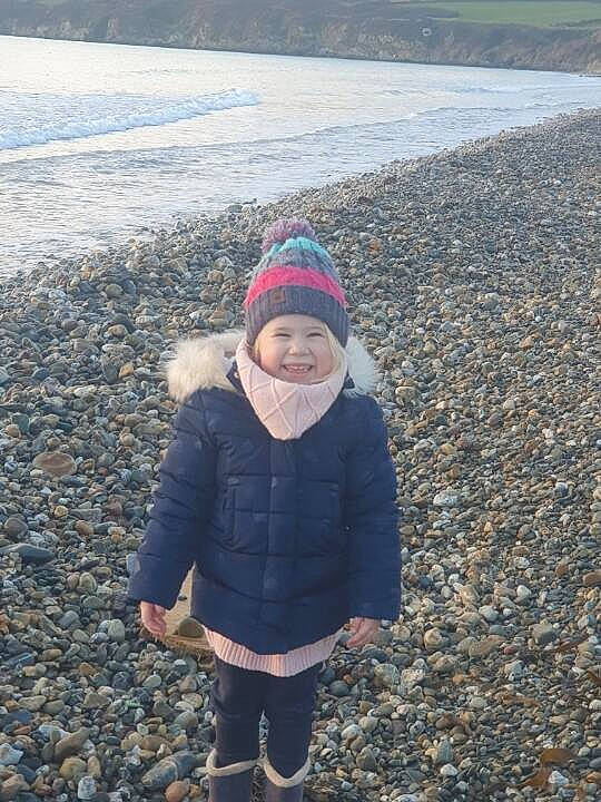Kayla participe au concours pour gagner de l'argent avec cette photo : asphalt, beach, body_of_water, cap, coast, fun, headwear, horizon, joy, lake, landscape, mountain, ocean, people_in_nature, person, rock, sand, shore, smile, toddler