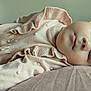 baby, sleeping, infant, pink_clothing, ruffles, pillow, soft_texture, peaceful, close_up, face, head, child, cute, resting, indoors, portrait, newborn, skin, cozy, calm