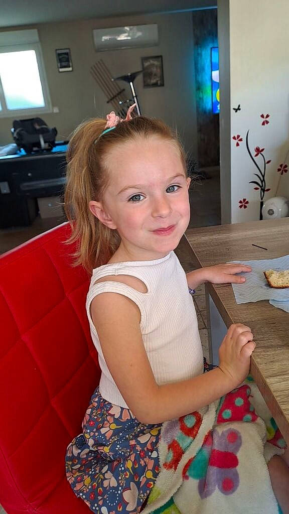 Mia participe au concours pour gagner de l'argent avec cette photo : baby_toddler_clothing, blond, chair, cheek, child, event, flooring, fun, happy, iris, joy, long_hair, person, room, sitting, skin, smile, standing, sunglasses, television