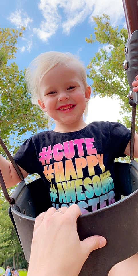 Tayler is registered to the contest to win money with this photo: baby_carriage, cloud, facial_expression, finger, fun, grass, hand, happy, human_body, joy, leisure, people_in_nature, person, pink, plant, sky, sleeve, smile, summer, t_shirt