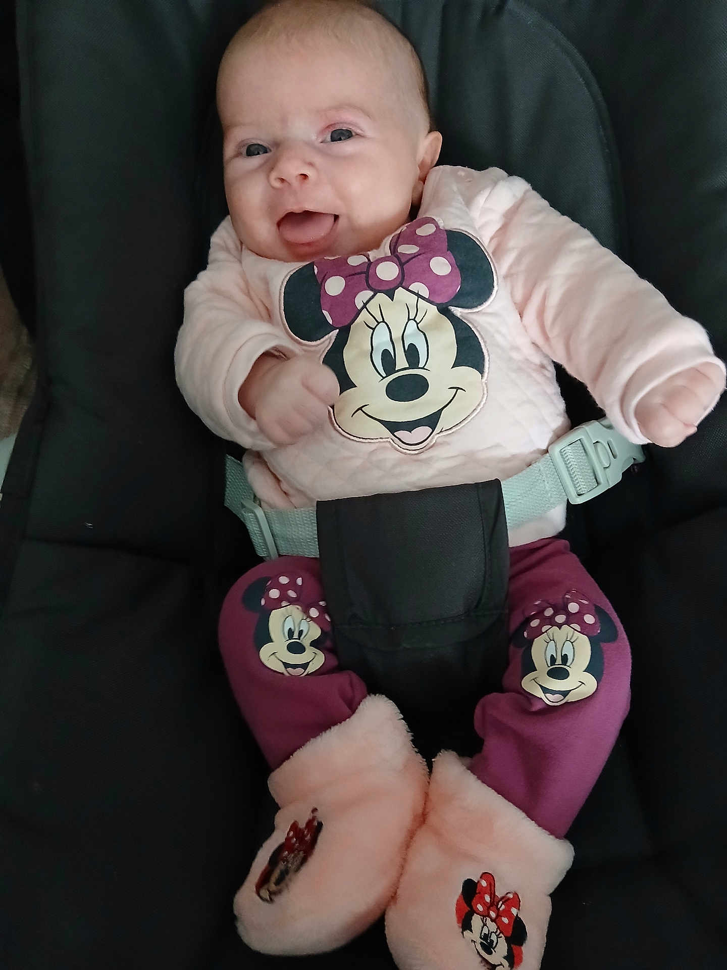 Eva participe au concours pour gagner de l'argent avec cette photo : baby, child, smiling, minnie_mouse, clothing, seat_belt, car_seat, pink, purple, boots, cute, happy, portrait, infant, face, person, sitting, apparel, cartoon_character, indoor