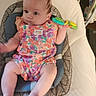 Elaina is registered to the contest to win money with this photo: baby, child, infant, sitting, colorful_clothing, toy, baby_seat, cushion, indoor, curious_expression, person, face, head, limbs, patterned_clothing, bright_colors, soft_lighting, closeup, young_child, playful