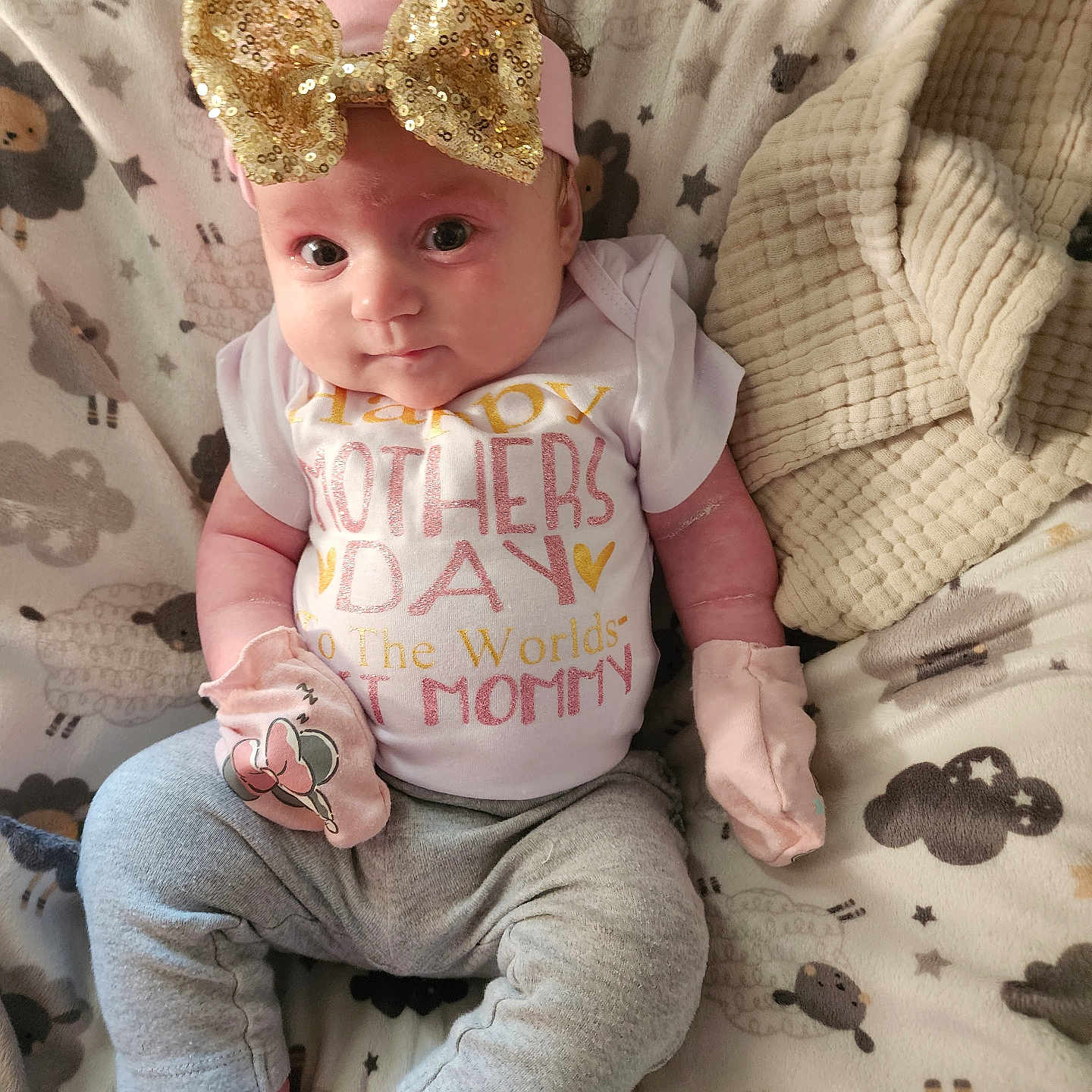 Elaina joined the competition — help win amazing prizes! baby, infant, headband, bow, mittens, blanket, sheep_pattern, clothing, sitting, cute, pink, gray_pants, portrait, indoors, child, young, soft_texture, cozy, happy, face