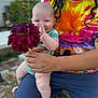 baby, adult, flower, purple_flower, tie_dye_shirt, shorts, outdoor, garden, bench, smiling, happy, person, holding, plant, nature, playful, child, casual_clothing, summer, daylight