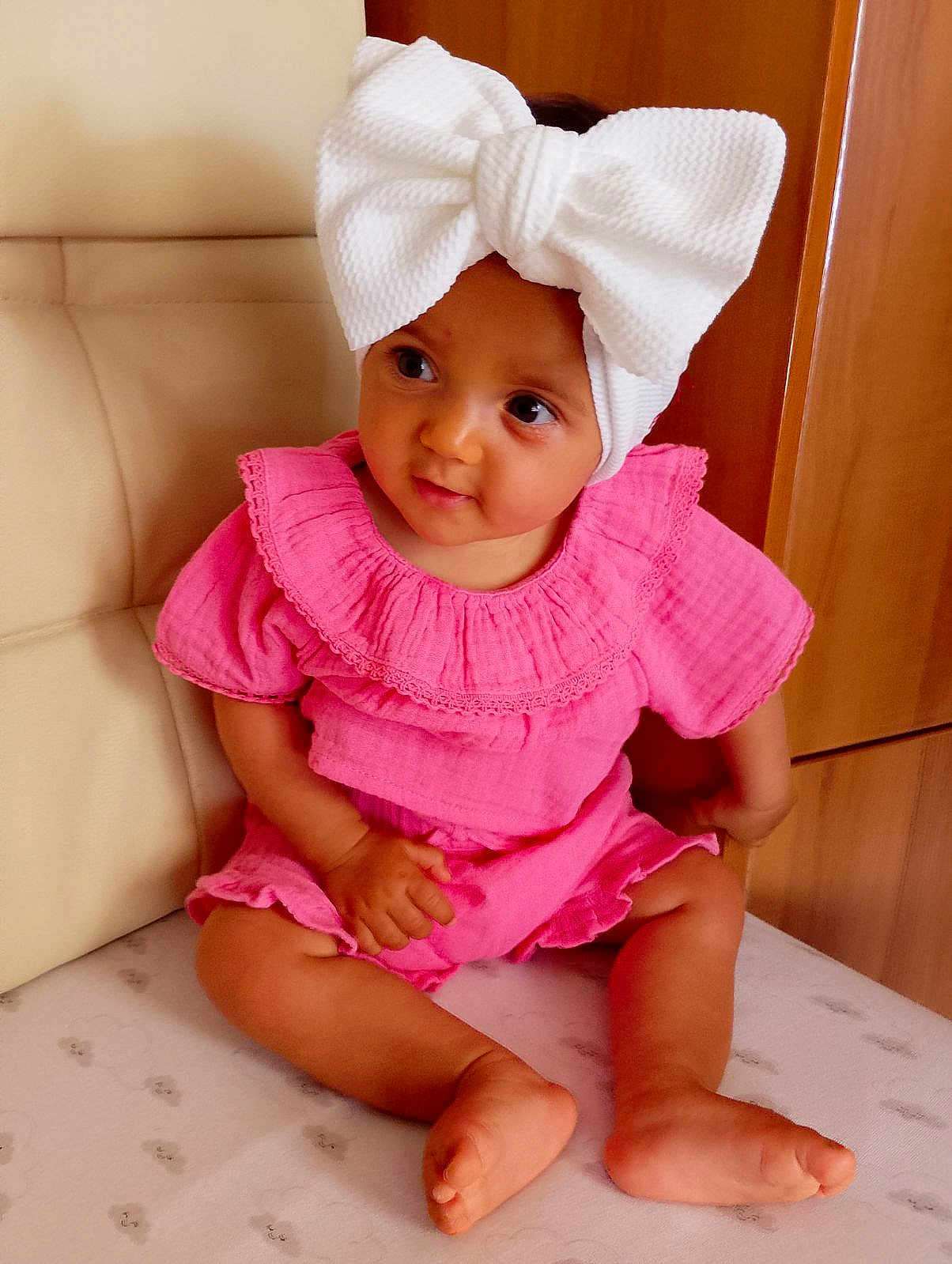 Jywai participe au concours pour gagner de l'argent avec cette photo : baby, infant, child, bow, headwrap, pink_dress, sitting, bare_feet, hands, big_bow, portrait, indoor, chair, wooden_cabinet, mattress, cute, smile, brown_eyes, skin, fabric