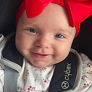 Naëlya a rejoint le concours — aidez-le/la à gagner de superbes lots ! baby, smiling, red_bow, car_seat, floral_outfit, close_up, infant, face, child, cute, portrait, happy, straps, pink_blanket, headwear, young_child, baby_girl, seatbelt, indoor, soft_toys
