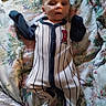 Oryan joined the competition — help win amazing prizes! baby, infant, onesie, striped_clothing, red_lettering, blanket, floral_pattern, bed, resting, lying_down, young_child, cute, portrait, indoor, person, small_hands, footed_pajamas, soft_lighting, casual, comfortable
