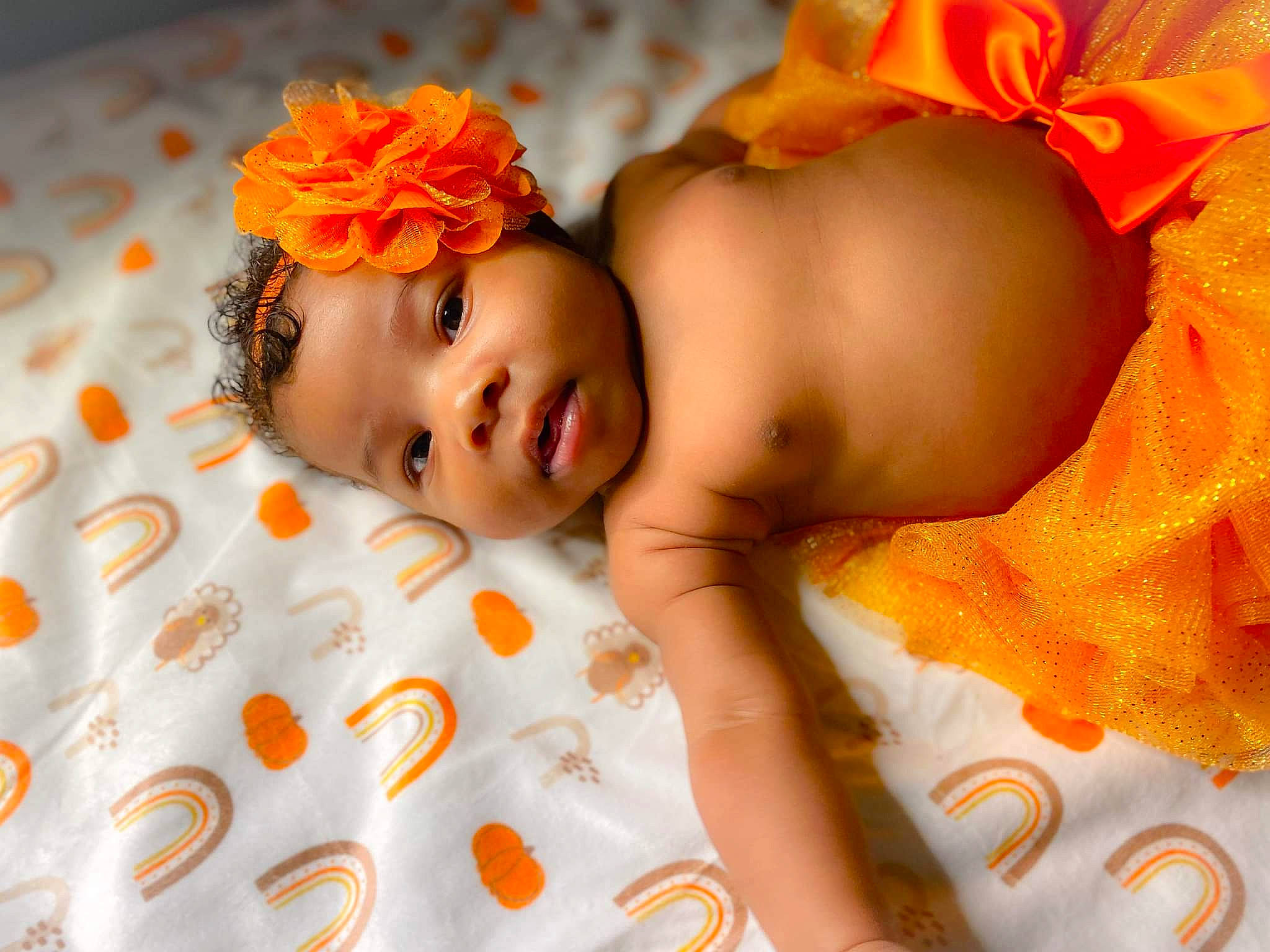 Kiara is registered to the contest to win money with this photo: baby, baby_products, baby_sleeping, baby_toddler_clothing, bedtime, child, comfort, fashion_accessory, finger, flower, happy, headband, headgear, headpiece, linens, orange, pattern, person, skin, textile