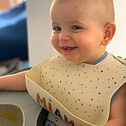 Marcel participe au concours pour gagner de l'argent avec cette photo : baby, child, smiling, bib, food, messy, face, highchair, feeding, spoon, bowl, indoor, person, happy, cute, infant, meal, clothing, table, closeup