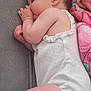baby, sleeping, infant, onesie, blanket, thumb_sucking, soft_surface, peaceful, cute, child, skin, pink, white_clothing, curled_up, resting, indoors, young, portrait, head, hand