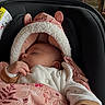 baby, sleeping, car_seat, blanket, pink, hood, ears, floral_pattern, infant, cozy, indoor, restaurant, table, chair, window, person, clothing, peaceful, cute, child