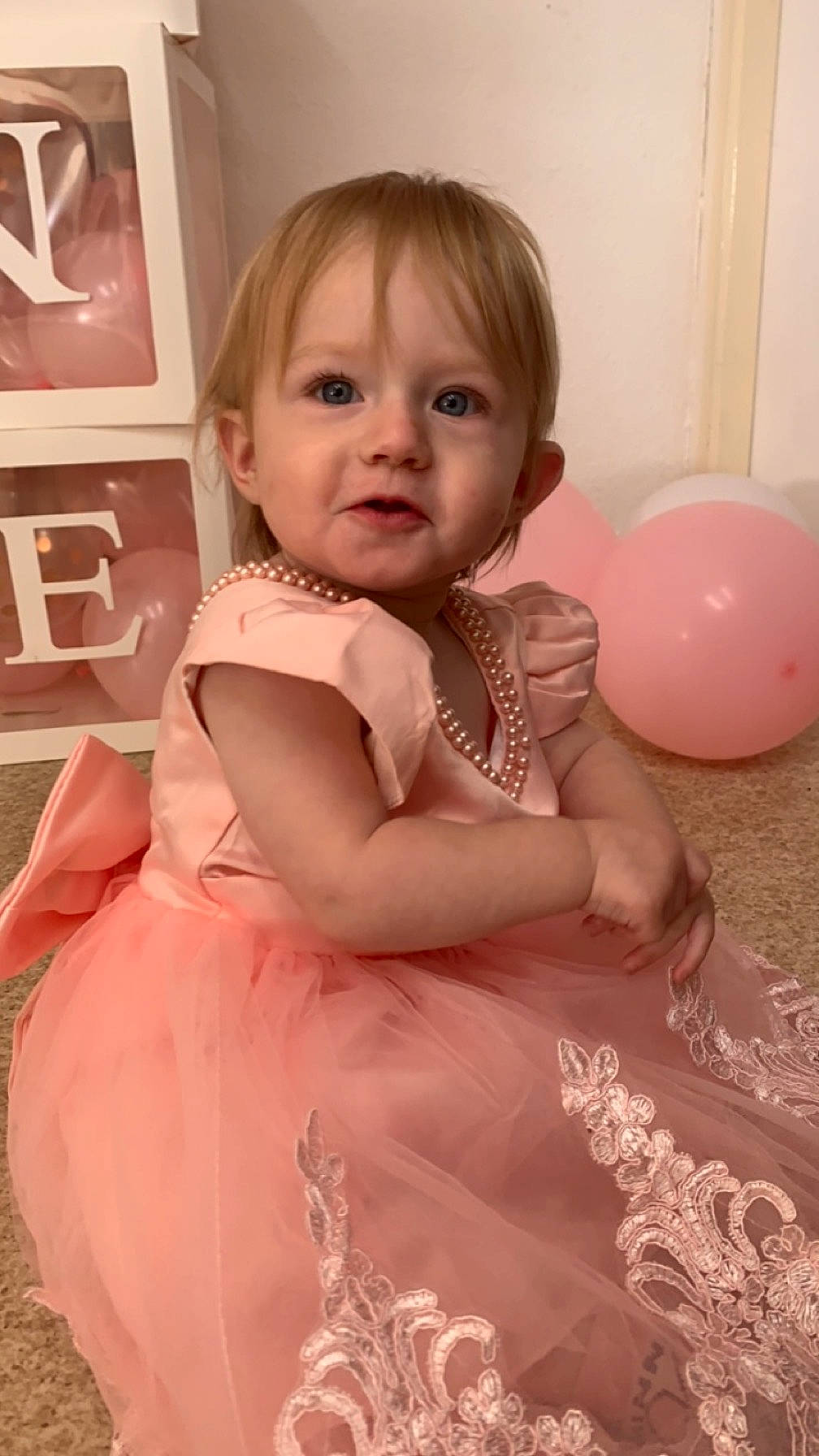 Juliette a rejoint le concours — aidez-le/la à gagner de superbes lots ! baby, baby_toddler_clothing, balloon, blond, child, day_dress, dress, event, flooring, formal_wear, fun, happy, iris, jewellery, party_supply, peach, person, pink, sitting, skin