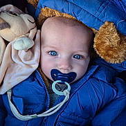 Arthur participe au concours pour gagner de l'argent avec cette photo : adorable, baby, blanket, blue_coat, blue_eyes, bundle_up, calm, closeup, eye_contact, face, gaze, hood, infant, pacifier, pacifier_clip, plush, portrait, stuffed_toy, winter_jacket, zipper