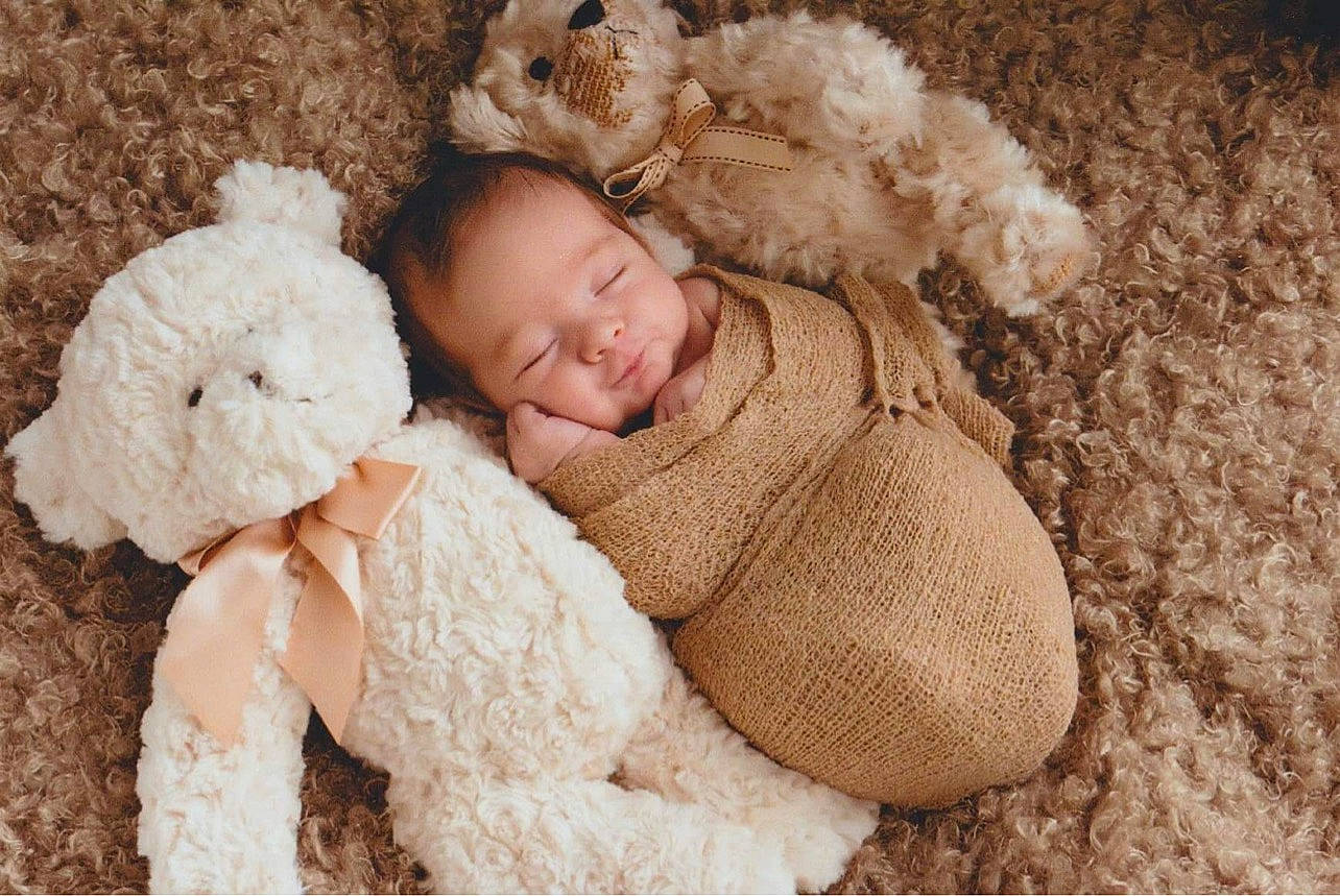 Keli joined the competition — help win amazing prizes! baby, baby_sleeping, baby_toddler_clothing, cap, comfort, fawn, fur_clothing, grass, hat, headgear, outerwear, person, plant, shoe, sitting, skin, stuffed_toy, teddy_bear, toddler, toy