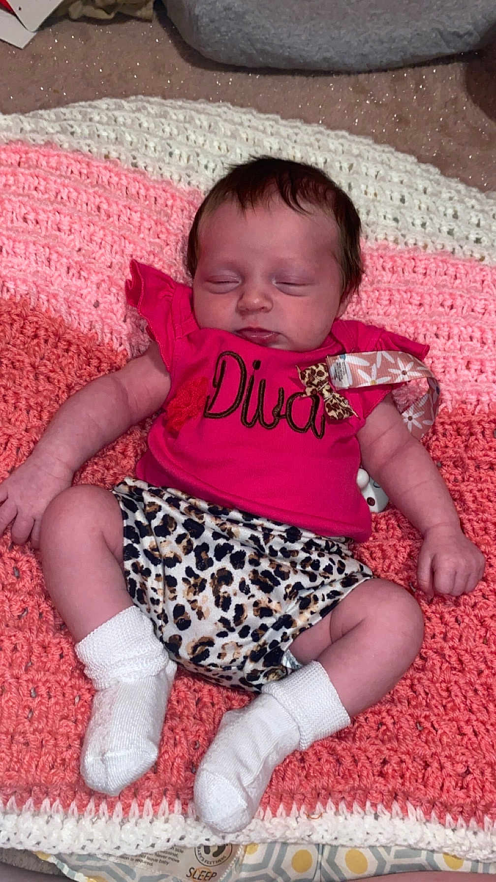 Oakleyy is registered to the contest to win money with this photo: baby, sleeping, infant, pink_shirt, leopard_print, socks, crocheted_blanket, hand, face, clothing, cute, resting, indoor, newborn, person, soft_texture, pattern, cozy, small, peaceful