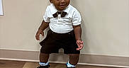 Demonte joined the competition — help win amazing prizes! black_shorts, bow_tie, boy, casual, child, cute, fashion, floor, gold_chain, happy, indoor, person, portrait, smiling, sneakers, standing, toddler, wall, white_shirt, wooden_floor