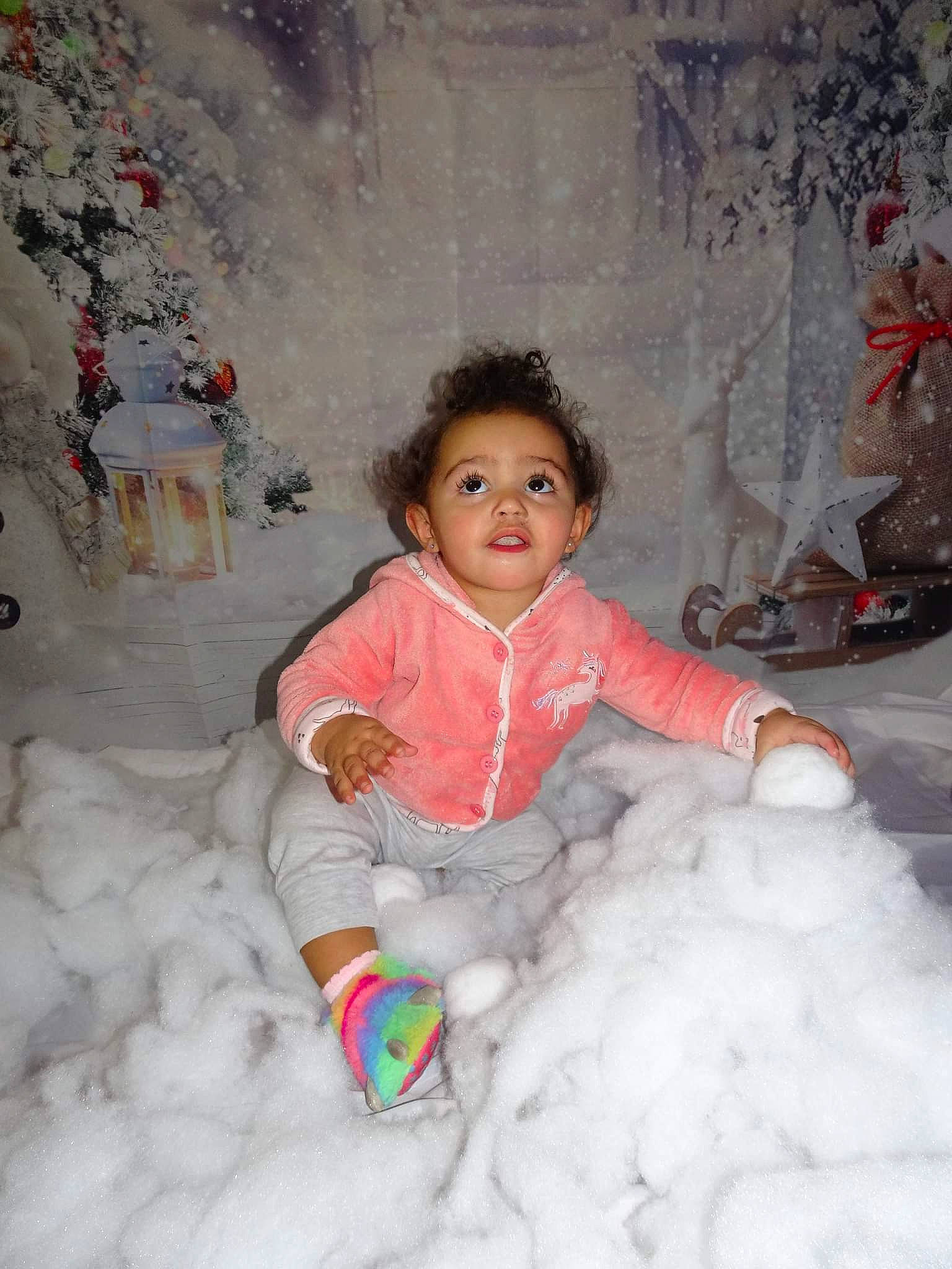 Allie is registered to the contest to win money with this photo: baby_toddler_clothing, cheek, child, event, eye, freezing, fun, fur, happy, head, iris, nose, person, pink, playing_in_the_snow, sitting, snow, standing, toddler, winter