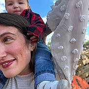Waylen is registered to the contest to win money with this photo: child, baby, woman, portrait, smile, shoulder_ride, outdoor, blue_sky, clouds, plaid_shirt, denim, sock, white_blouse, trees, close_up, candid, family, happy, fence, sunlight