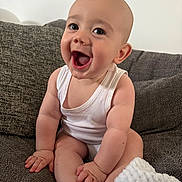 Alfie joined the competition — help win amazing prizes! baby, blanket, child, couch, cute, eyes, face, furniture, hands, happy, indoor, infant, legs, mouth, person, portrait, sitting, skin, smiling, white_tank_top