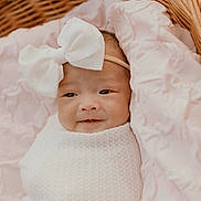 Aurora Win is registered to the contest to win money with this photo: baby, infant, bow, headband, blanket, wicker_basket, pink, white, smile, face, portrait, cute, soft, cozy, newborn, child, wrapped, resting, indoors, person