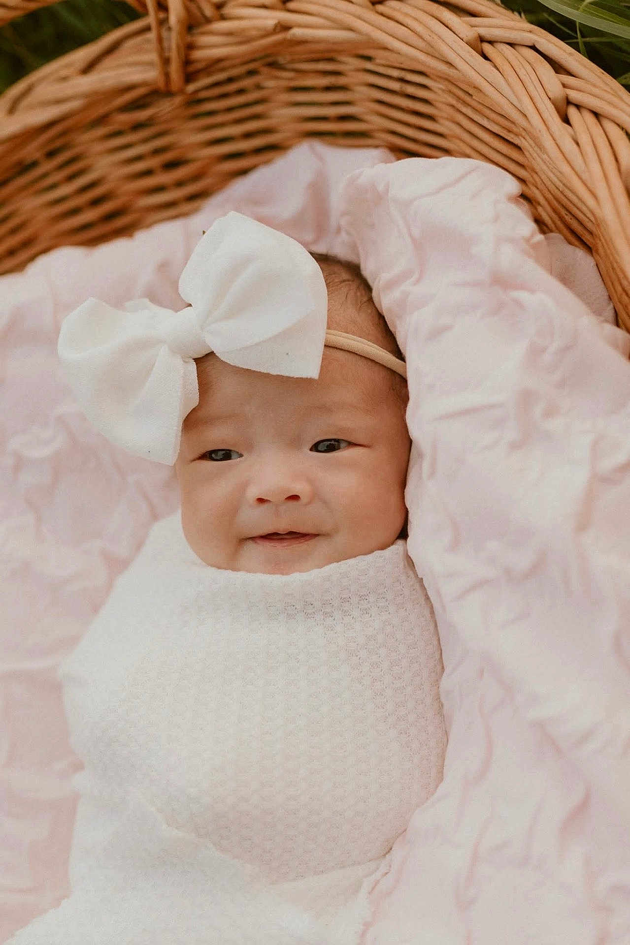 Aurora Win is registered to the contest to win money with this photo: baby, infant, bow, headband, blanket, wicker_basket, pink, white, smile, face, portrait, cute, soft, cozy, newborn, child, wrapped, resting, indoors, person