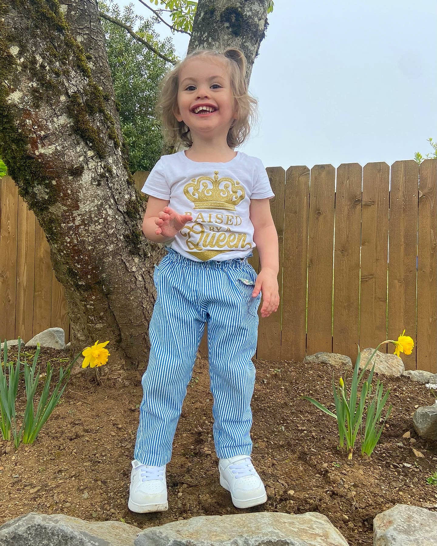Elizabeth is registered to the contest to win money with this photo: child, denim, face, flower, grass, hair, happy, head, joy, leaf, leg, people_in_nature, person, plant, sky, sleeve, smile, standing, t_shirt, toddler
