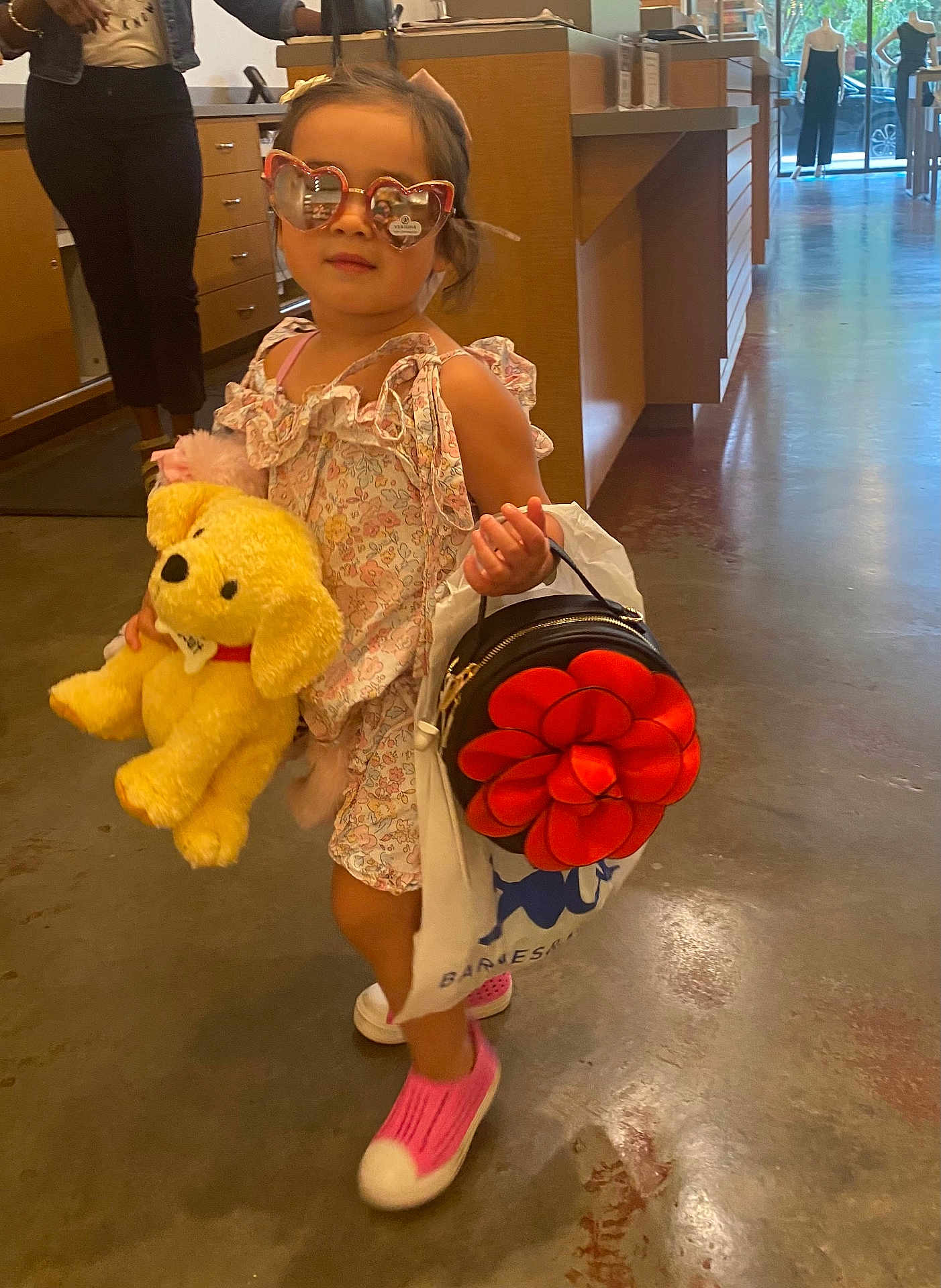 Evelyn is registered to the contest to win money with this photo: child, indoor, girl, sunglasses, plush_toy, handbag, dress, pink_shoes, floor, shopping_bag, person, fashion, cute, toy, accessories, walking, concrete_floor, window, reflection, casual