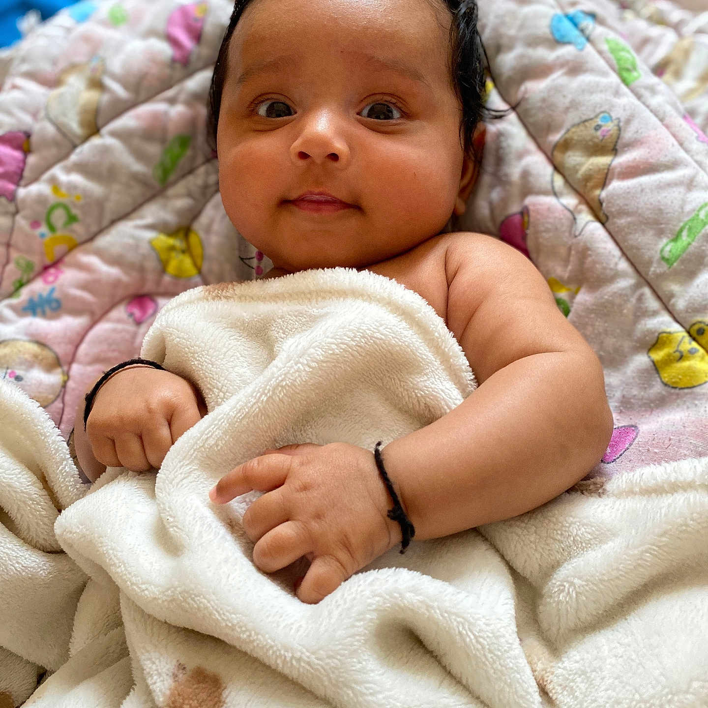 Yaavi is registered to the contest to win money with this photo: baby, black_hair, blanket, child, closeup, comfortable, cute, expression, face, hand, indoors, infant, newborn, portrait, quilt, resting, skin, smile, soft, warm