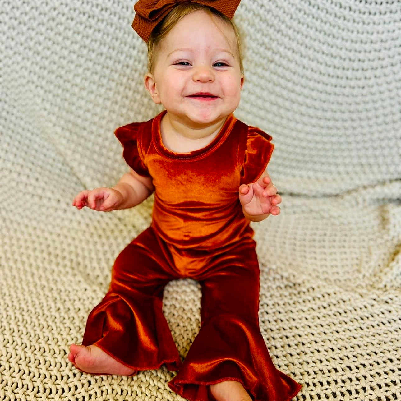 Indie Sage is registered to the contest to win money with this photo: baby, blonde, clothing, costume, cushion, dress, face, formalwear, furniture, hair, happy, head, homedecor, laughing, pants, person, photography, portrait, sitting, smile