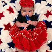 Ayla joined the competition — help win amazing prizes! baby, infant, child, tutu, headband, red_clothing, black_clothing, blue_toy, star_pattern, blanket, cute, indoor, portrait, sitting, hands, feet, fabric, soft_texture, holiday_theme, celebration