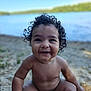 baby, child, curly_hair, smiling, sitting, lake, water, sand, outdoor, nature, happy, portrait, young_child, bare_chest, sunlight, summer, playful, innocence, cute, closeup