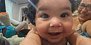 Romeo is registered to the contest to win money with this photo: baby, smile, face, child, person, indoor, toys, curly_hair, adult, glasses, window, curtain, bed, blanket, happy, closeup, selfie, room, casual, portrait