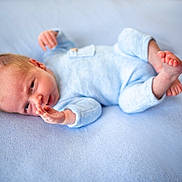 Tiarnán joined the competition — help win amazing prizes! baby, blanket, blue_onesie, child, closeup, curious, cute, expression, face, foot, hand, indoors, infant, lying_down, newborn, portrait, skin, sleepwear, small, soft_texture