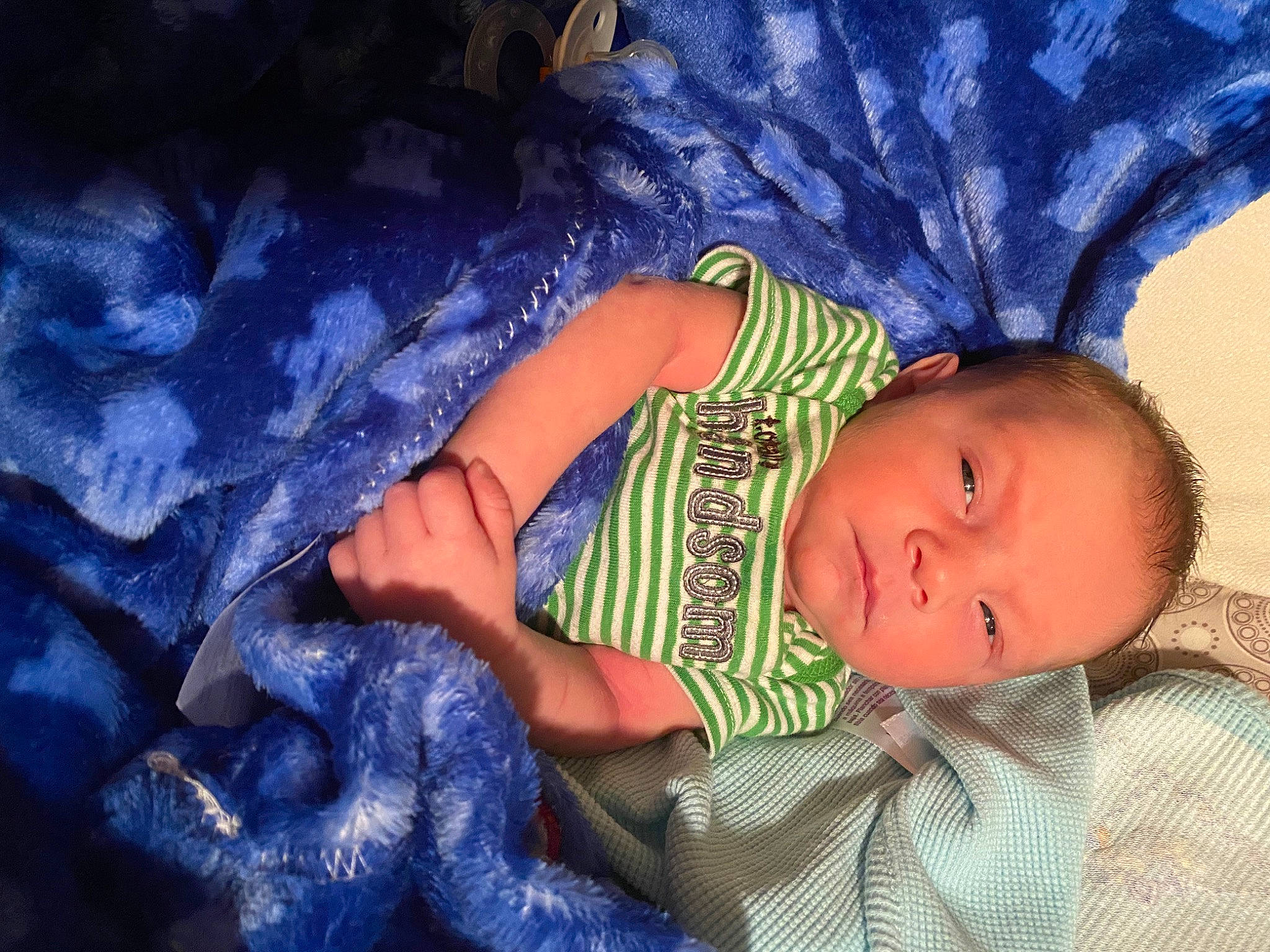 Raymond is registered to the contest to win money with this photo: baby, baby_toddler_clothing, cheek, child, comfort, electric_blue, eye, finger, gesture, human_body, iris, linens, nose, pattern, person, purple, skin, sleeve, textile, toddler