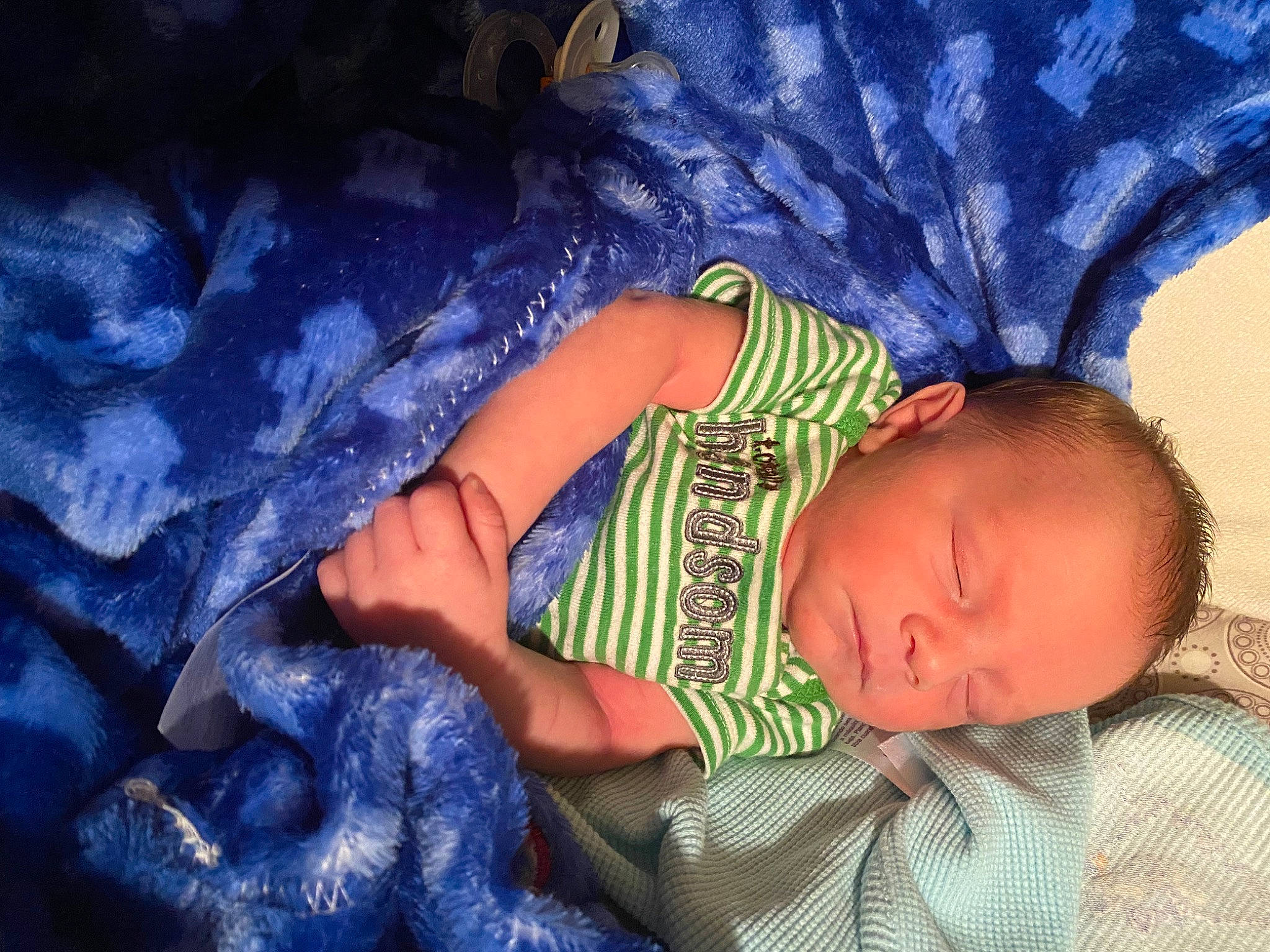 Raymond is registered to the contest to win money with this photo: baby, baby_toddler_clothing, bedtime, blue, child, comfort, electric_blue, finger, fun, hand, happy, linens, nose, pattern, person, purple, room, sitting, textile, tints_and_shades