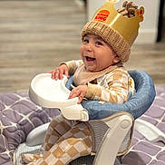 Azael joined the competition — help win amazing prizes! baby, child, high_chair, crown, burger_king, knit_hat, smiling, indoor, plaid_clothing, footed_pajamas, happy, person, seat, quilt, floor, baby_clothes, infant, cute, headwear, cheerful