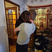 Suky participe au concours pour gagner de l'argent avec cette photo : dog, labrador, chocolate_lab, person, hugging, indoor, portrait, pet, companion, brown_dog, collar, large_dog, standing, cuddle, home, doorway, egyptian_art, wall_hanging, cleaning_equipment, household