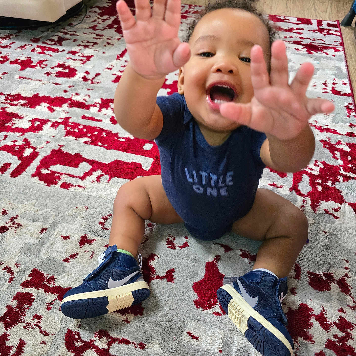 Enkore joined the competition — help win amazing prizes! baby, blue_clothing, carpet, child, cute, furniture, hands, happy, home, indoor, person, playful, portrait, reaching, rug, sitting, smiling, sneakers, toddler, wood_floor