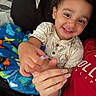 Amir joined the competition — help win amazing prizes! toddler, child, smiling, portrait, indoors, cuddling, family, blanket, dinosaur_blanket, red_shirt, cream_shirt, curly_hair, brown_eyes, baby, happy, close_up, seated, hands, fingernails, cozy