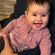 Olivia a rejoint le concours — aidez-le/la à gagner de superbes lots ! baby, smiling, child, pink_clothing, floral_pattern, cat_design, happy, portrait, face, hand, sitting, cute, indoor, person, long_sleeve, human, infant, holding, closeup, joyful