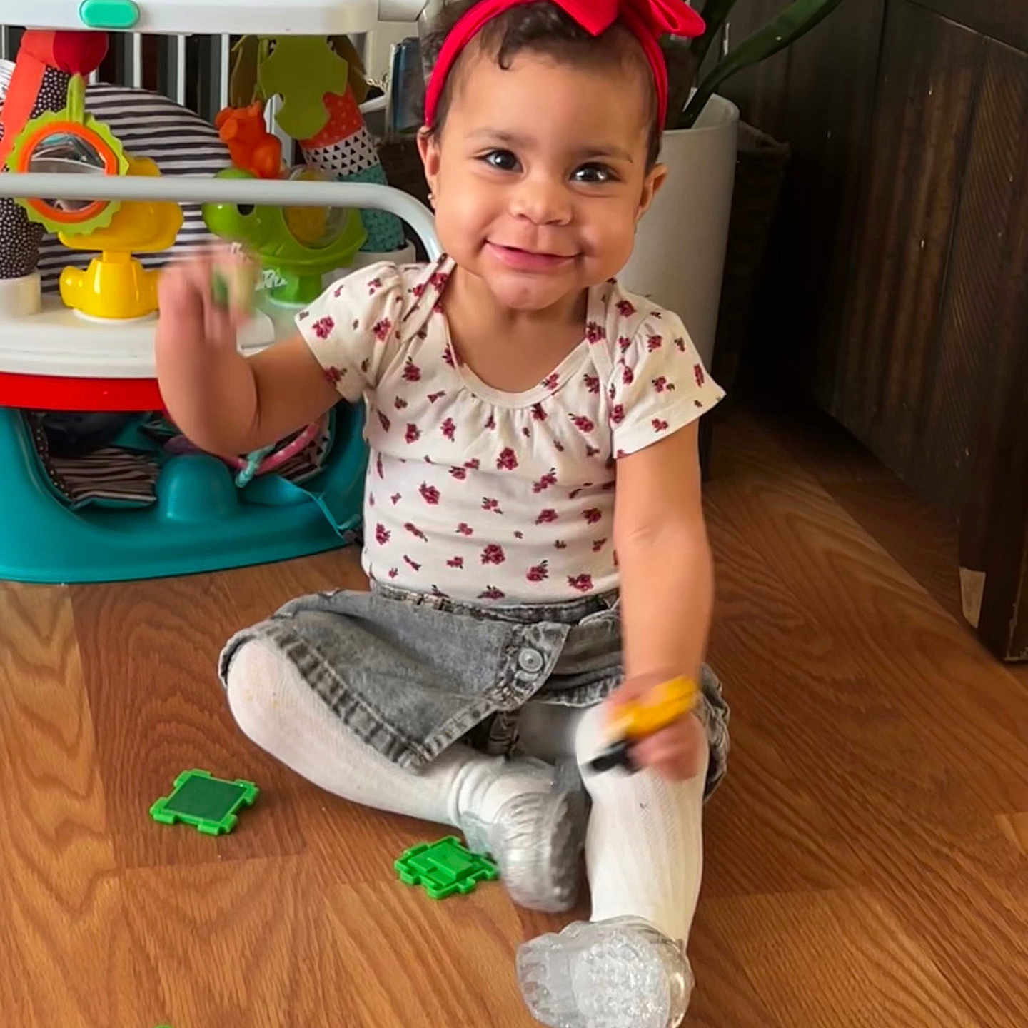 Amoura is registered to the contest to win money with this photo: baby, clothing, face, footwear, furniture, hardwood, head, indoors, interiordesign, pants, person, photography, plant, portrait, pottedplant, shoe, sitting, t_shirt, toy, wood