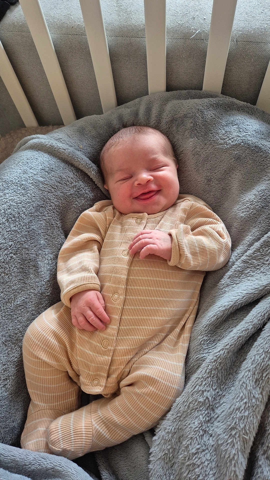 Ambre participe au concours pour gagner de l'argent avec cette photo : baby, infant, smile, onesie, striped_clothing, blanket, crib, sleepwear, cozy, happy, child, newborn, cute, soft_texture, furniture, bedroom, resting, comfort, portrait, indoor