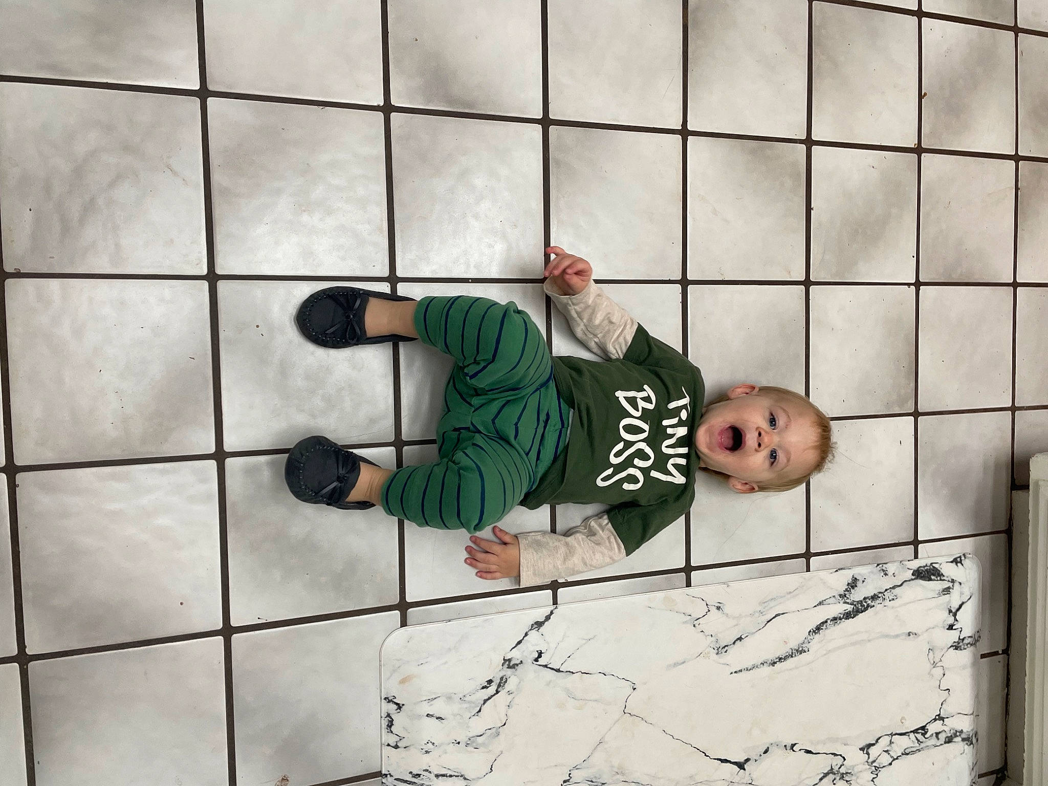 Nikolai joined the competition — help win amazing prizes! child, concrete, floor, flooring, foot, hat, head, human_leg, knee, leg, pattern, person, plant, recreation, sitting, surprise, t_shirt, tile, toddler, tree