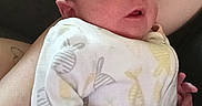 Meridith is registered to the contest to win money with this photo: newborn, baby, infant, onesie, fish_pattern, arm, couch, person, resting, comfortable, indoors, clothing, skin, face, head, hand, relaxing, casual, home, soft_lighting