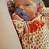 Meridith is registered to the contest to win money with this photo: baby, pacifier, infant, onesie, orange, floral, blanket, newborn, face, hand, sleepy, cute, indoors, soft_texture, closeup, person, child, cozy, wood_floor, resting