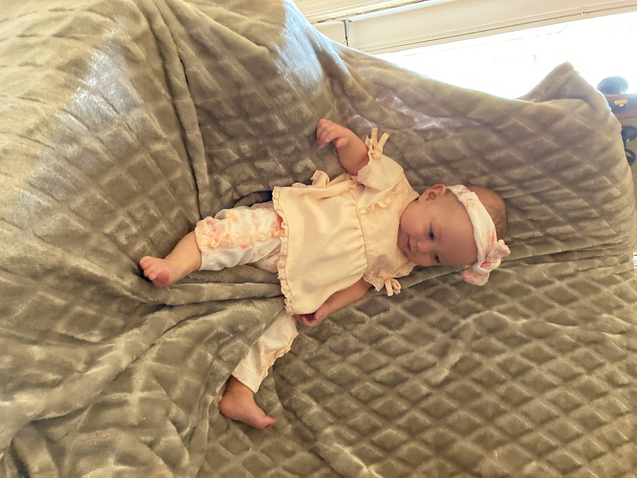 Charlotte is registered to the contest to win money with this photo: baby, baby_toddler_clothing, bedding, bedtime, child, comfort, flooring, foot, grass, hardwood, human_leg, linens, nap, pattern, person, room, sitting, sleeve, toddler, vertebrate