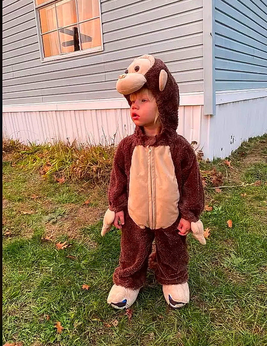 Oliver is registered to the contest to win money with this photo: baby_toddler_clothing, brick, child, costume, fur, garden, grass, happy, house, lawn_ornament, outerwear, pattern, people_in_nature, person, personal_protective_equipment, plant, siding, sleeve, toddler, window