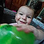 Everett joined the competition — help win amazing prizes! baby, child, smiling, green_ball, hand, face, indoor, playpen, wooden_door, toy, happy, cute, infant, portrait, room, furniture, clothing, person, baby_toy, closeup