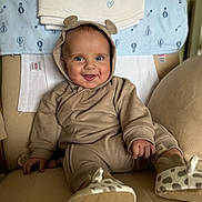 Arnie is registered to the contest to win money with this photo: baby, bear_ears, blanket, blue_eyes, chair, child, comfortable, cozy, cushion, cute, happy, hood, indoor, infant, newborn, onesie, portrait, smiling, soft_toys, towel